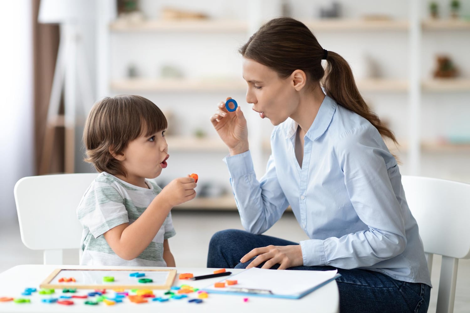 Speech-language pathologist doing a sound activity with a toddler during an assessment